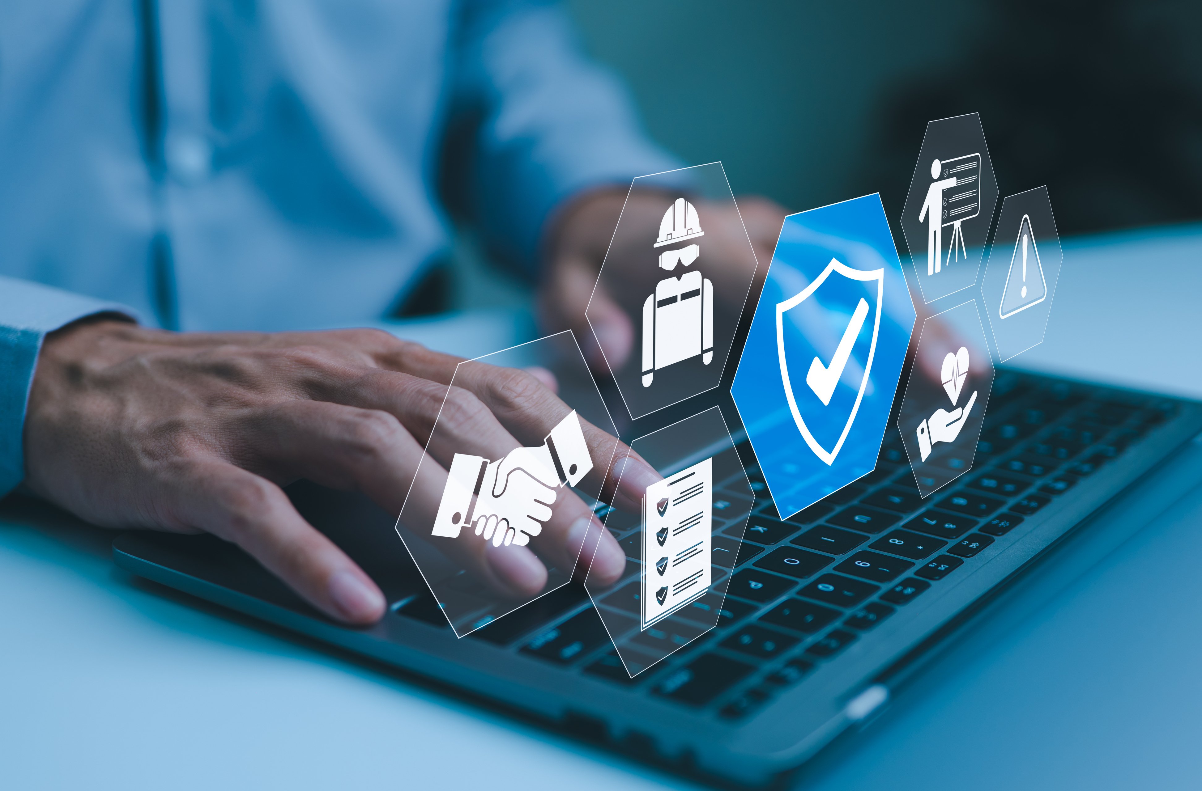Businessman typing on laptop with virtual icons representing work safety, compliance, and security, workplace safety, and regulatory adherence